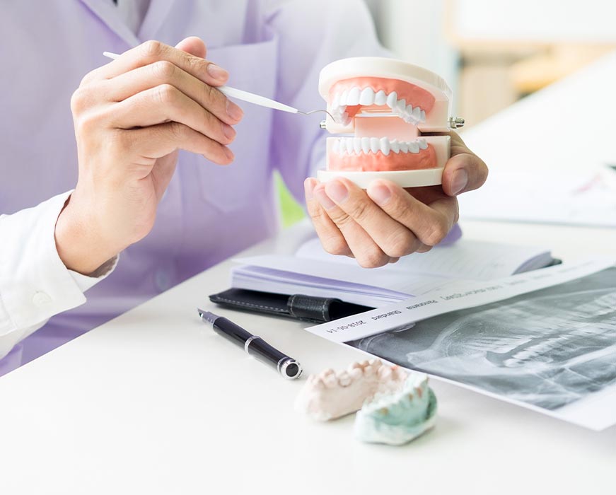 A dental professional examines teeth using a magnifying tool at a dental office.