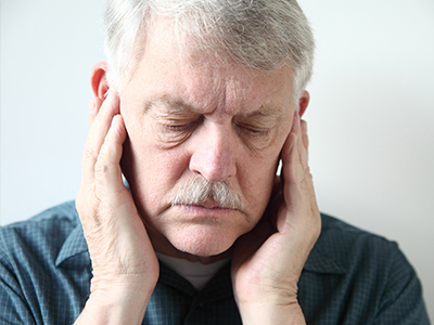 The image shows a man with his hand on his ear, appearing distressed or pained, with two different expressions side by side, suggesting a before-and-after comparison or perhaps a moment of transition between emotions.